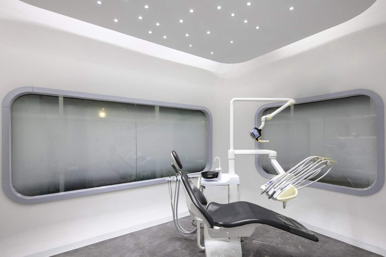 A modern dental clinic interior with a sleek dental chair and advanced dental equipment in a minimalist design. Perfect for showcasing contemporary dental office architecture and interior design.