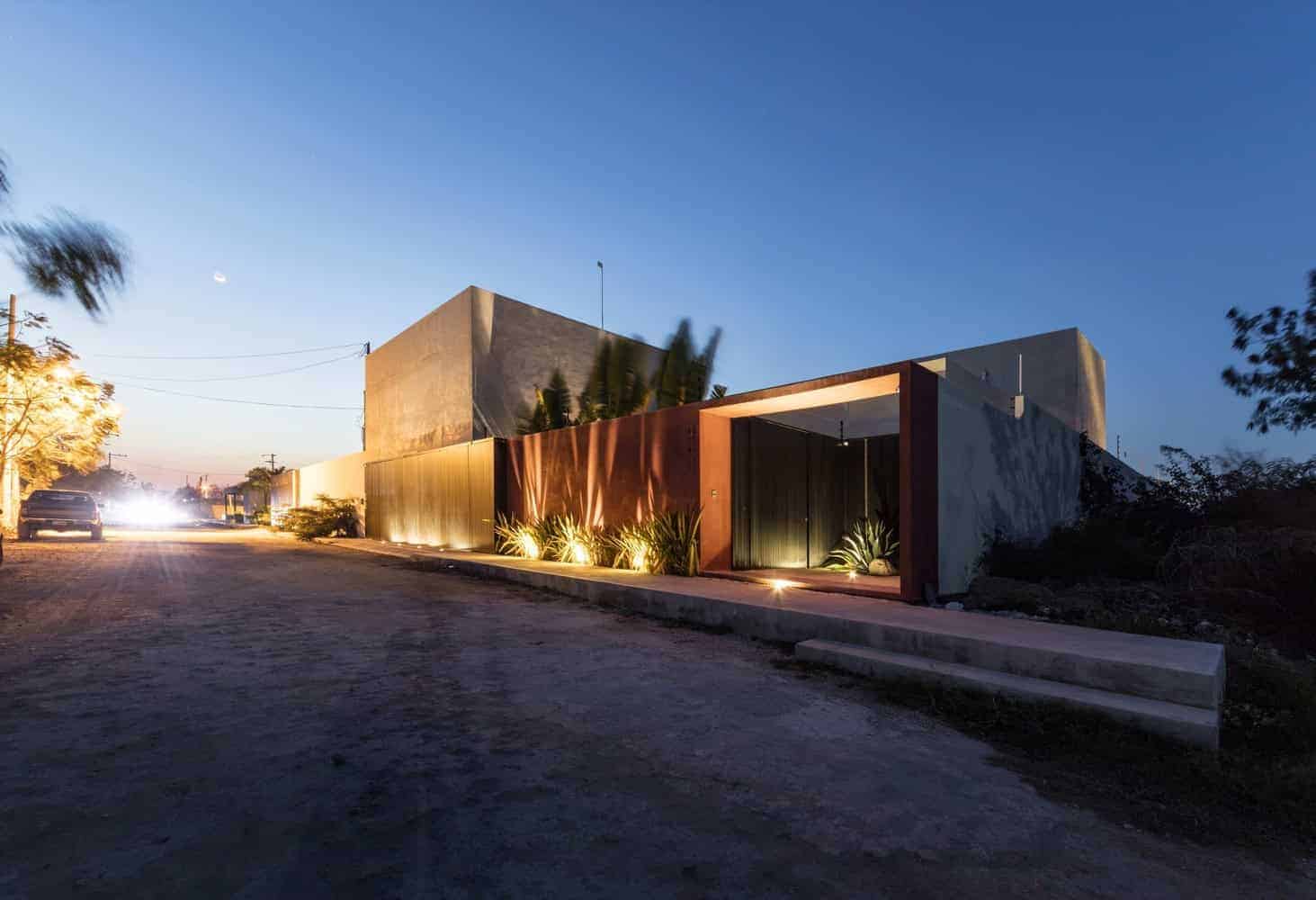 Contemporary modern house exterior at dusk with minimalist design, clean lines, and ambient lighting showcasing innovative architecture and stylish landscaping.
