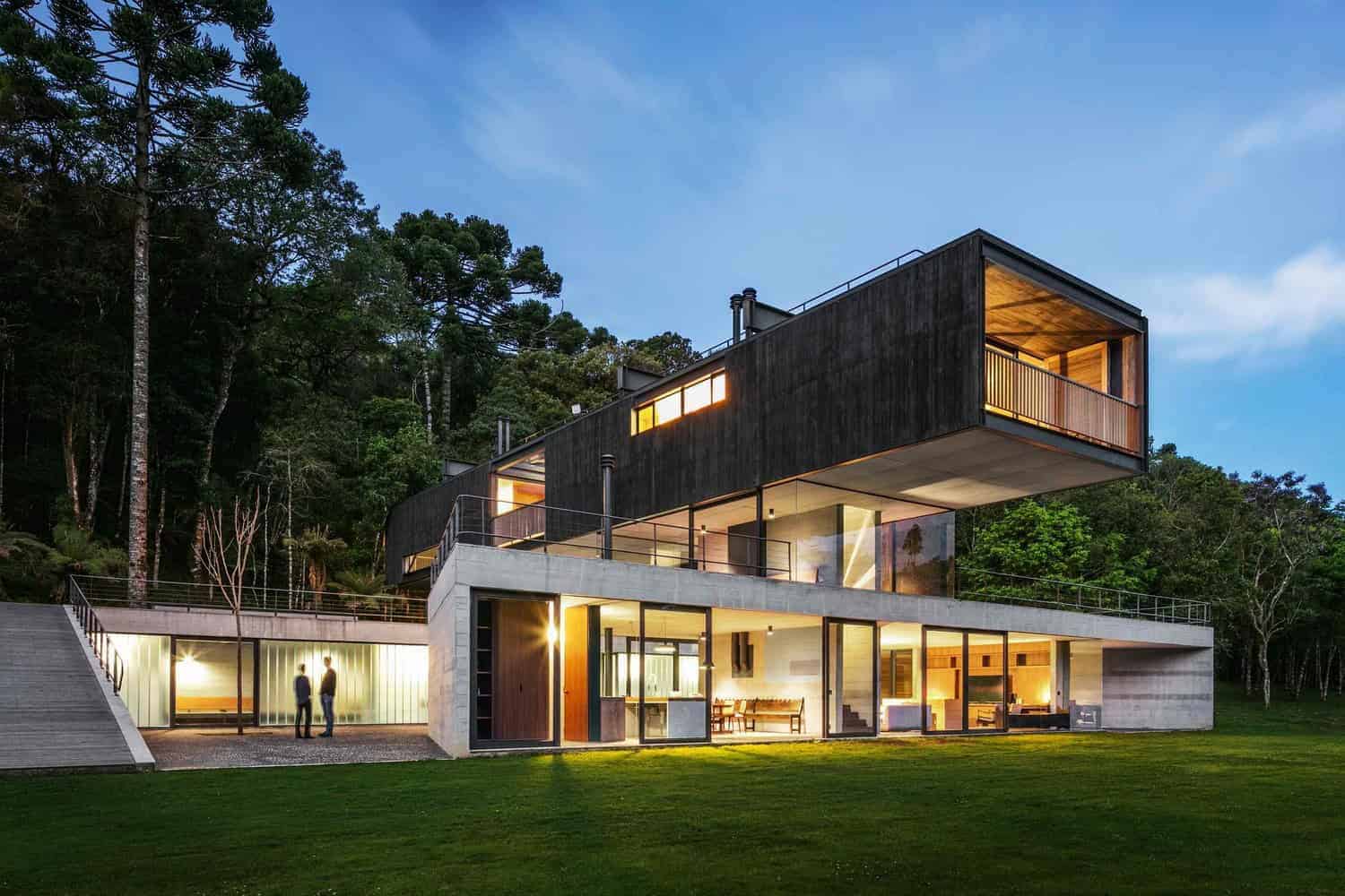 Contemporary modern house with innovative architectural design and large glass windows nestled among lush trees. Stylish exterior with bold geometric shapes, perfect for luxury residential architecture.