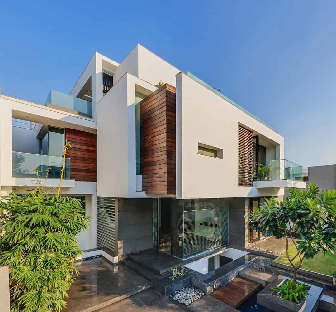 Modern house in india with a large pool and lush green lawn