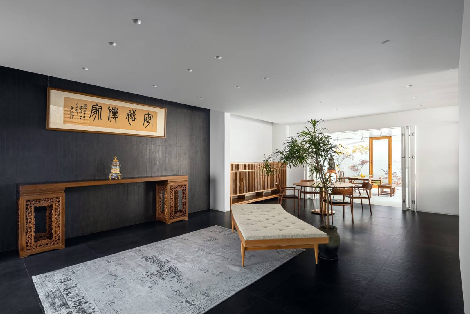 Elegant modern interior with minimalist Asian-inspired decor, wooden furniture, and large windows providing natural light, perfect for contemporary architecture and design enthusiasts.