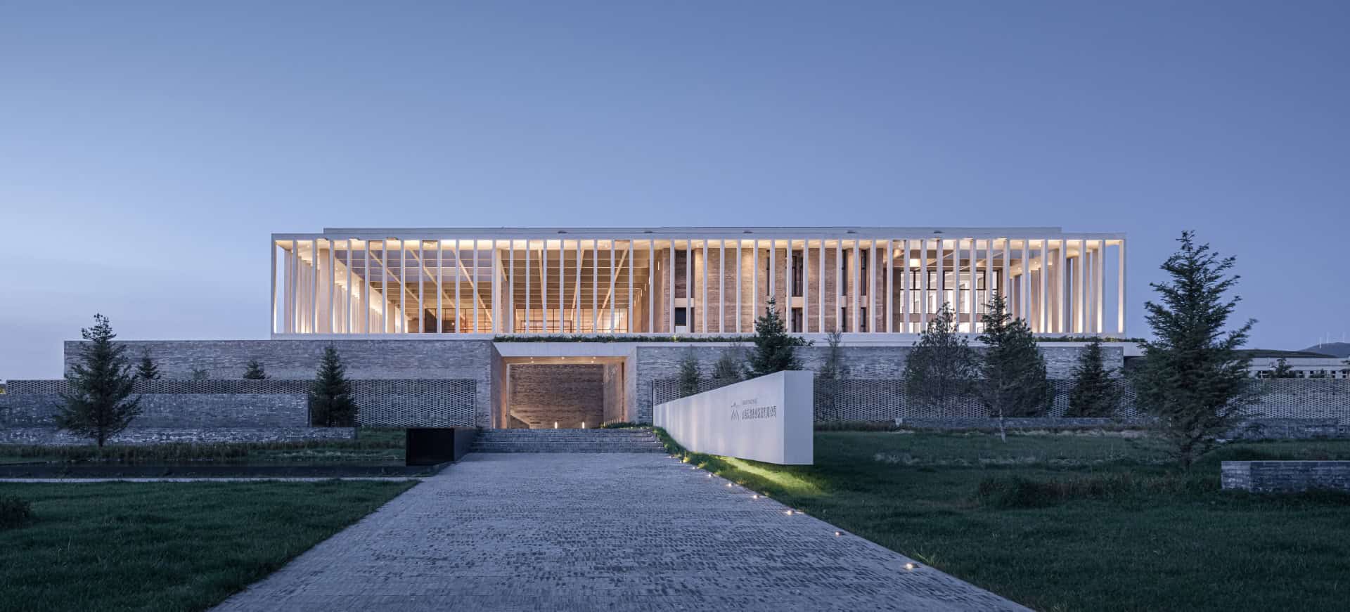 Modern architectural building with sleek design, illuminated at dusk, featuring contemporary structure, clean lines, and open spaces, exemplifying innovative architecture art and design.