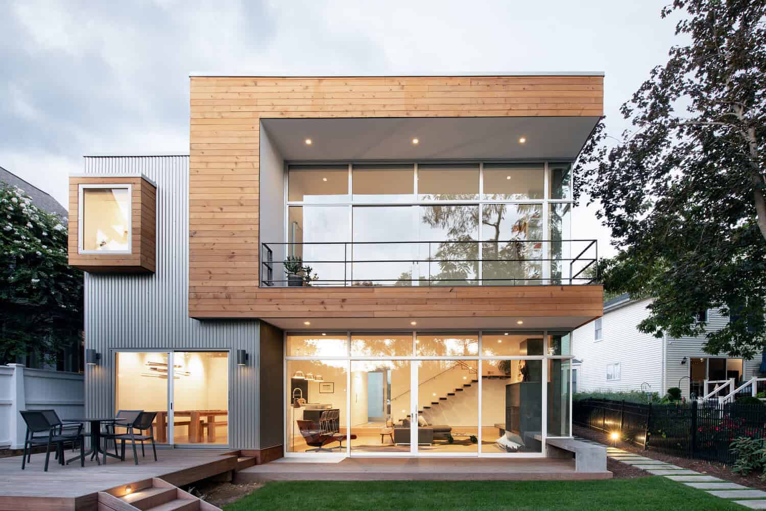 Contemporary modern house with wood and metal exterior, large glass windows, outdoor deck, and spacious interior design, showcasing innovative architecture and stylish residential architecture.
