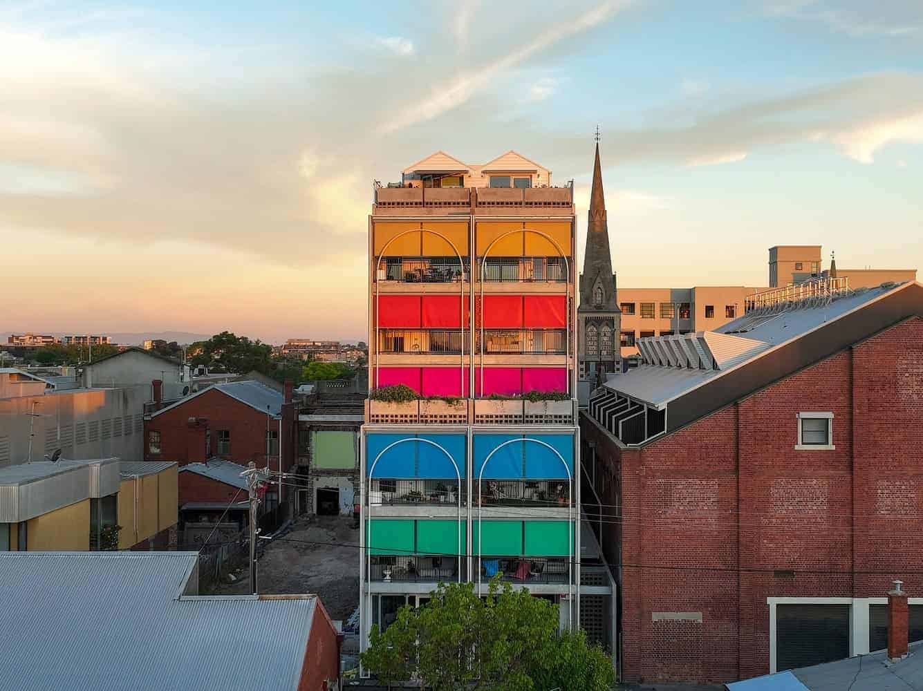 Colorful urban building with vibrant rainbow-colored balconies showcasing modern architecture and innovative design.