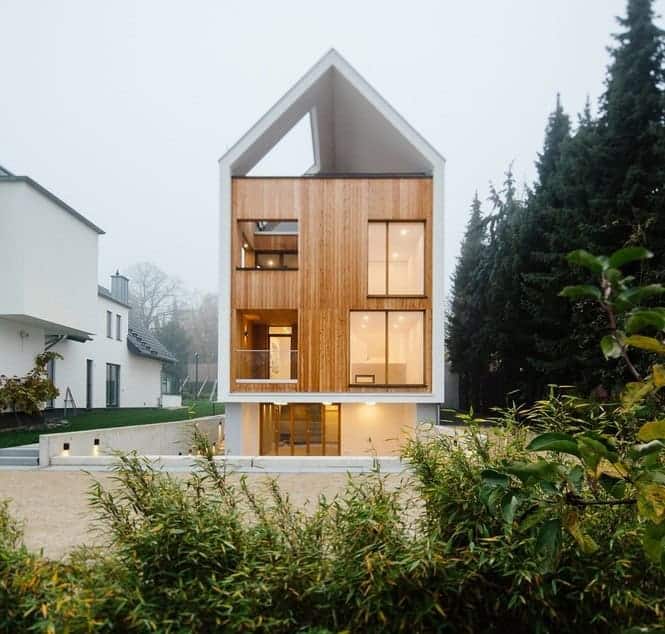 Modern minimalist house with wooden facade and large glass windows, contemporary architecture design, eco-friendly residential home, innovative house architecture, unique urban house design.