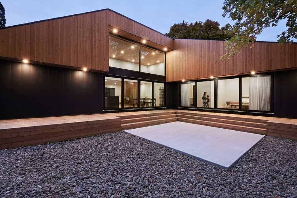Sleek modern house with wooden exterior and expansive glass windows, showcasing contemporary architecture and innovative design.