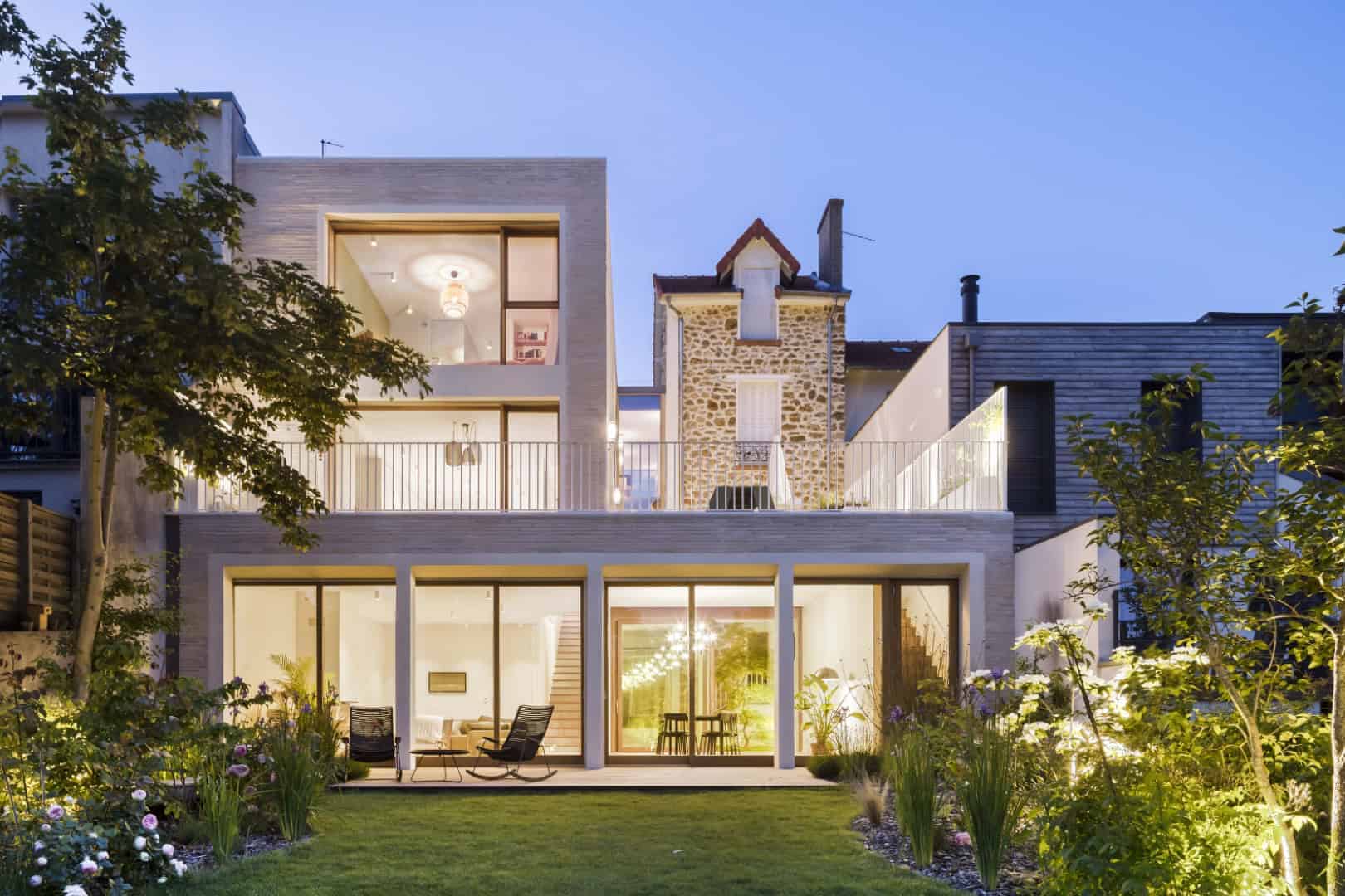 Sustainable modern house with large glass windows, outdoor patio, and landscaped garden showcasing contemporary architecture and innovative design.