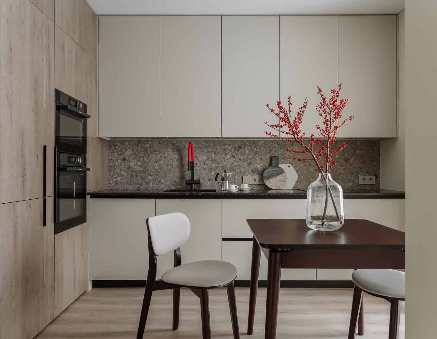 Sleek modern kitchen with minimalist design, light wood and white cabinetry, granite countertops, and stylish decor. Featuring a vase with red branches, perfect for contemporary architecture and interior design.