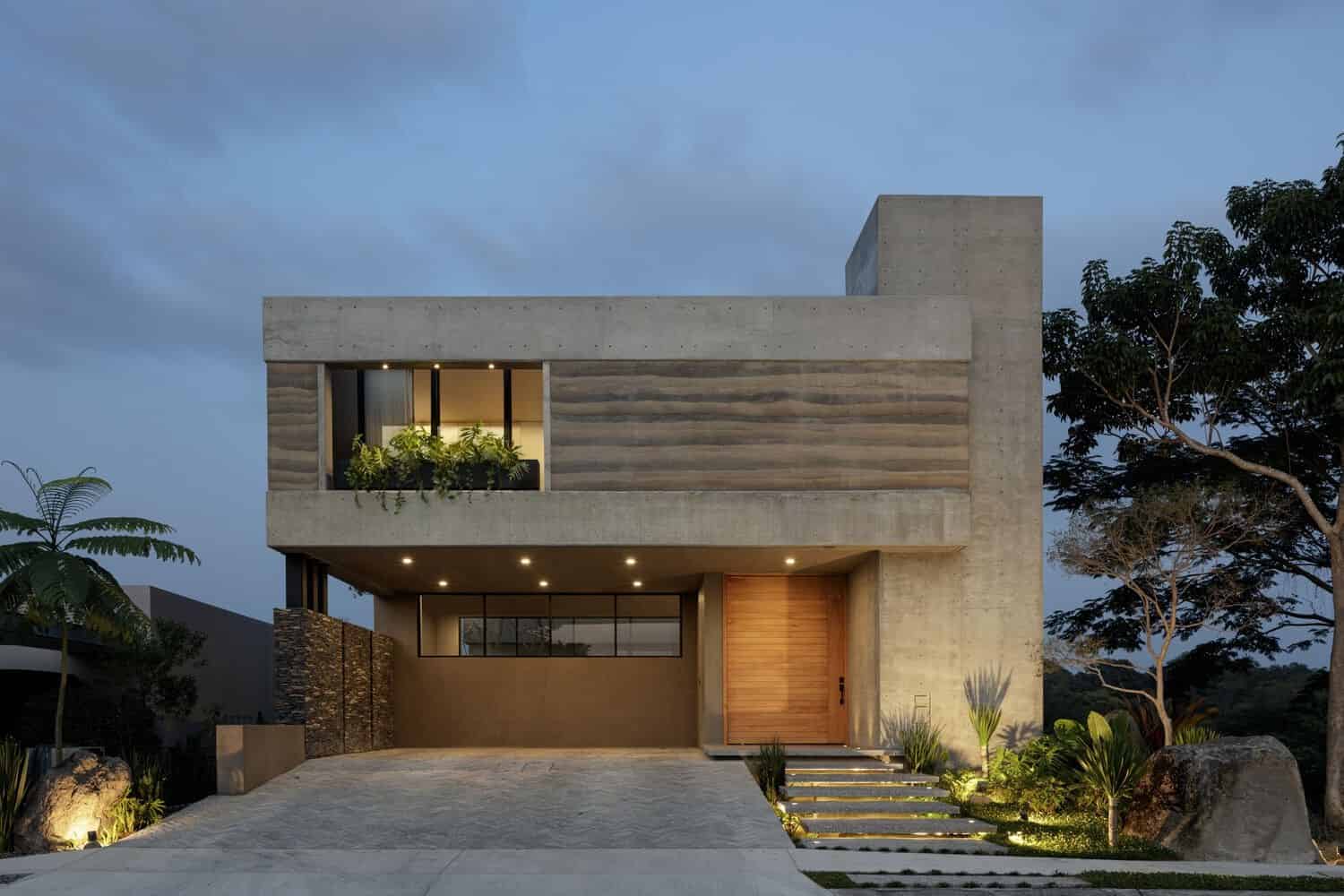Contemporary modern house with minimalist concrete facade and large glass windows, surrounded by lush landscaping and tropical trees. Elegant architectural design emphasizing clean lines and natural materials.