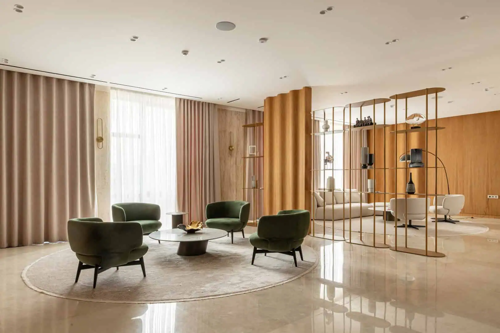 Luxurious modern hotel lounge with elegant green chairs, marble floors, and stylish decorative room dividers showcasing contemporary interior design.