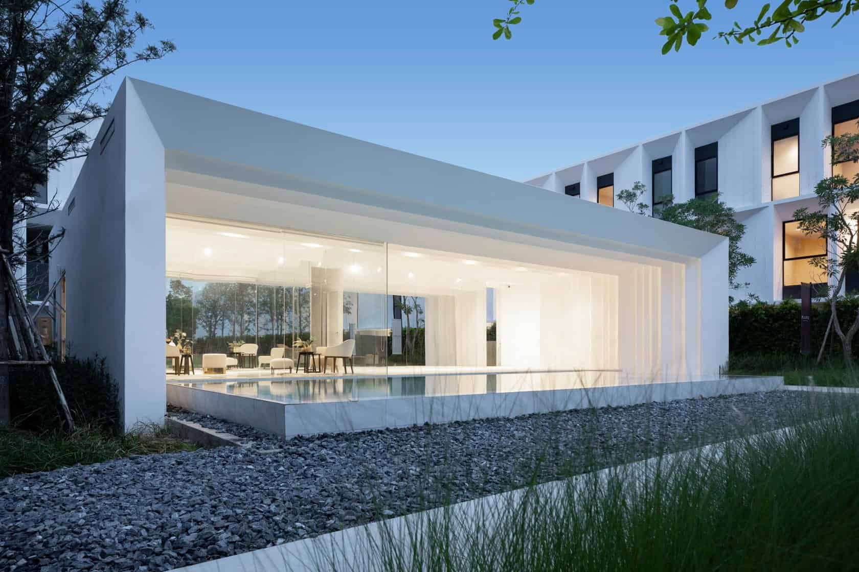 Modern minimalist house with glass walls and outdoor pool, contemporary architecture design, luxury home, sleek white exterior, innovative residential building, elegant outdoor living space.