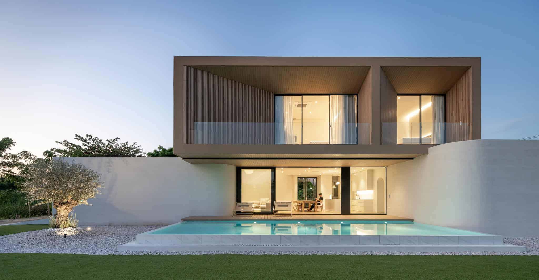 Modern minimalist two-story house with sleek design, large glass windows, and swimming pool in the backyard, showcasing contemporary architecture and stylish interior living space.