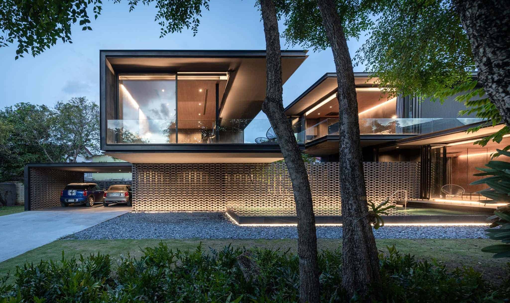 Modern contemporary house with floating glass balconies and sleek architectural design at dusk.