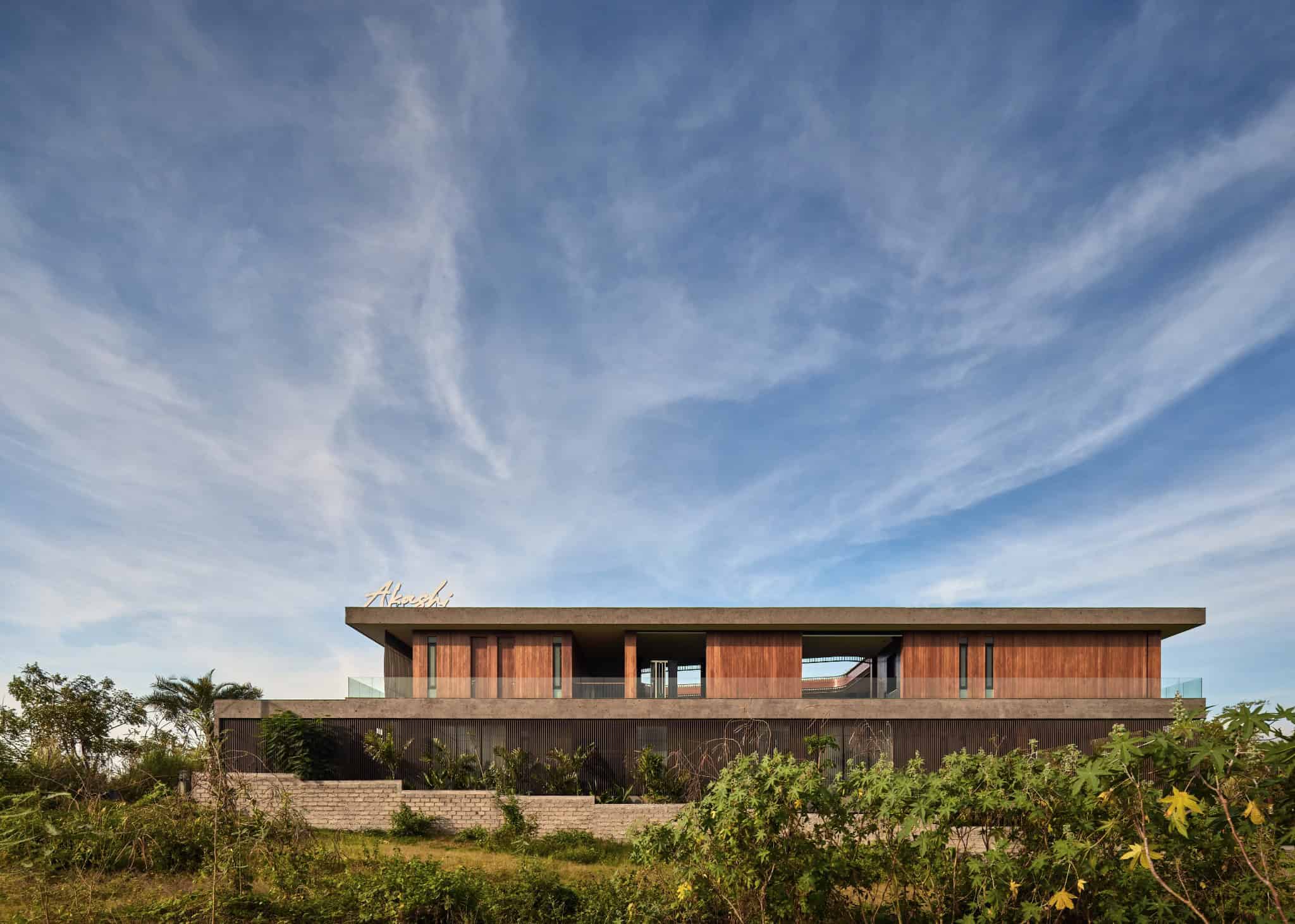 Modern minimalist architecture art design building with sleek lines, wooden accents, and open spaces against a bright blue sky.