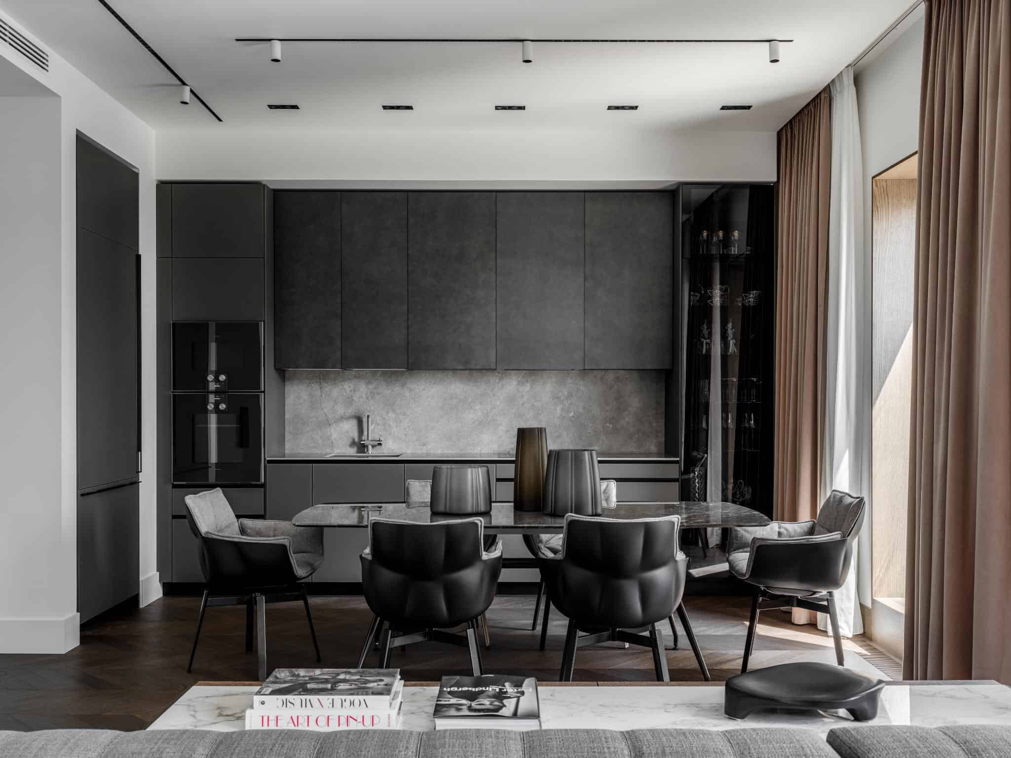 Modern monochrome kitchen and dining area with sleek black cabinetry, minimalist decor, and elegant design, showcasing contemporary architecture and interior styling.
