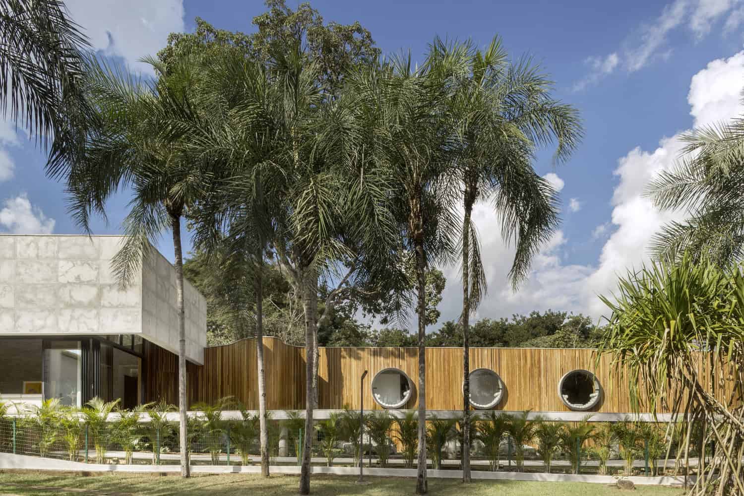 Exterior view of a modern house with round windows and tropical landscape