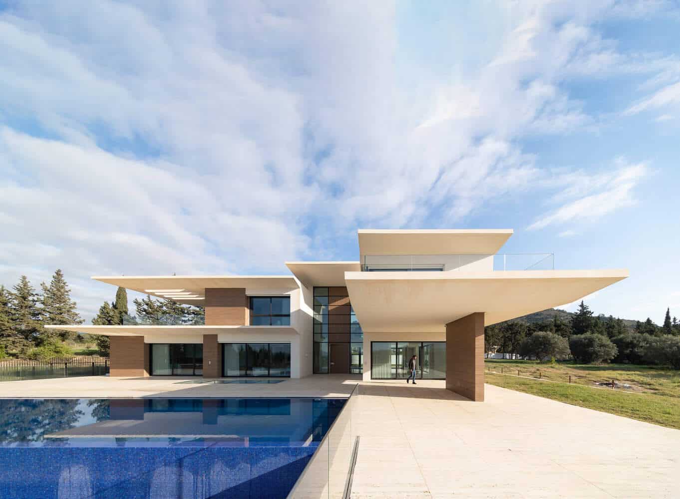 Contemporary minimalist house with bold architectural design, large glass windows, and a sleek pool, showcasing modern architecture and innovative residential design.