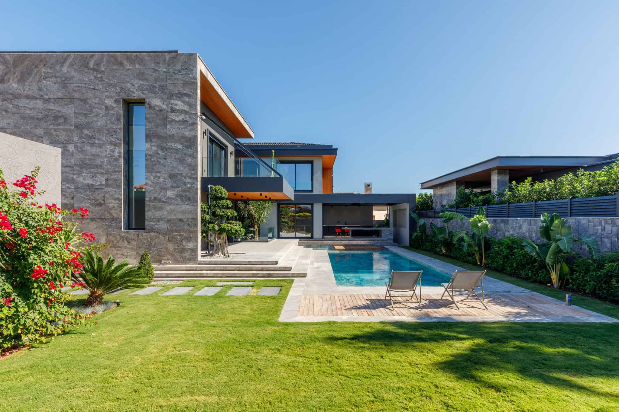 Modern luxury house with a sleek design, swimming pool, landscaped garden, and contemporary architecture. Perfect example of upscale residential property with stylish outdoor spaces.