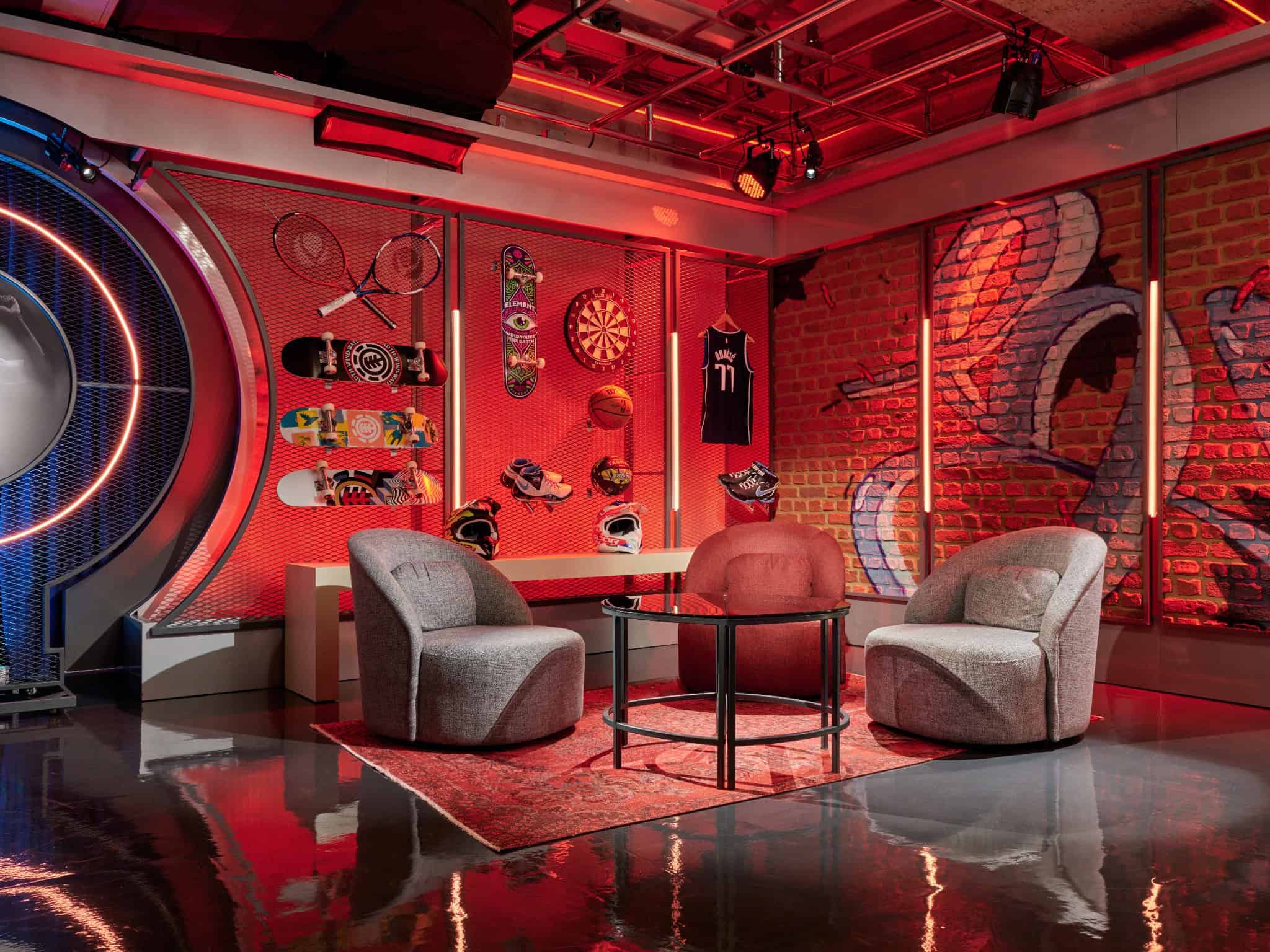 Vibrant modern sports lounge interior featuring exposed red brick walls, stylish seating, sports memorabilia, and dynamic lighting creating a trendy ambiance.