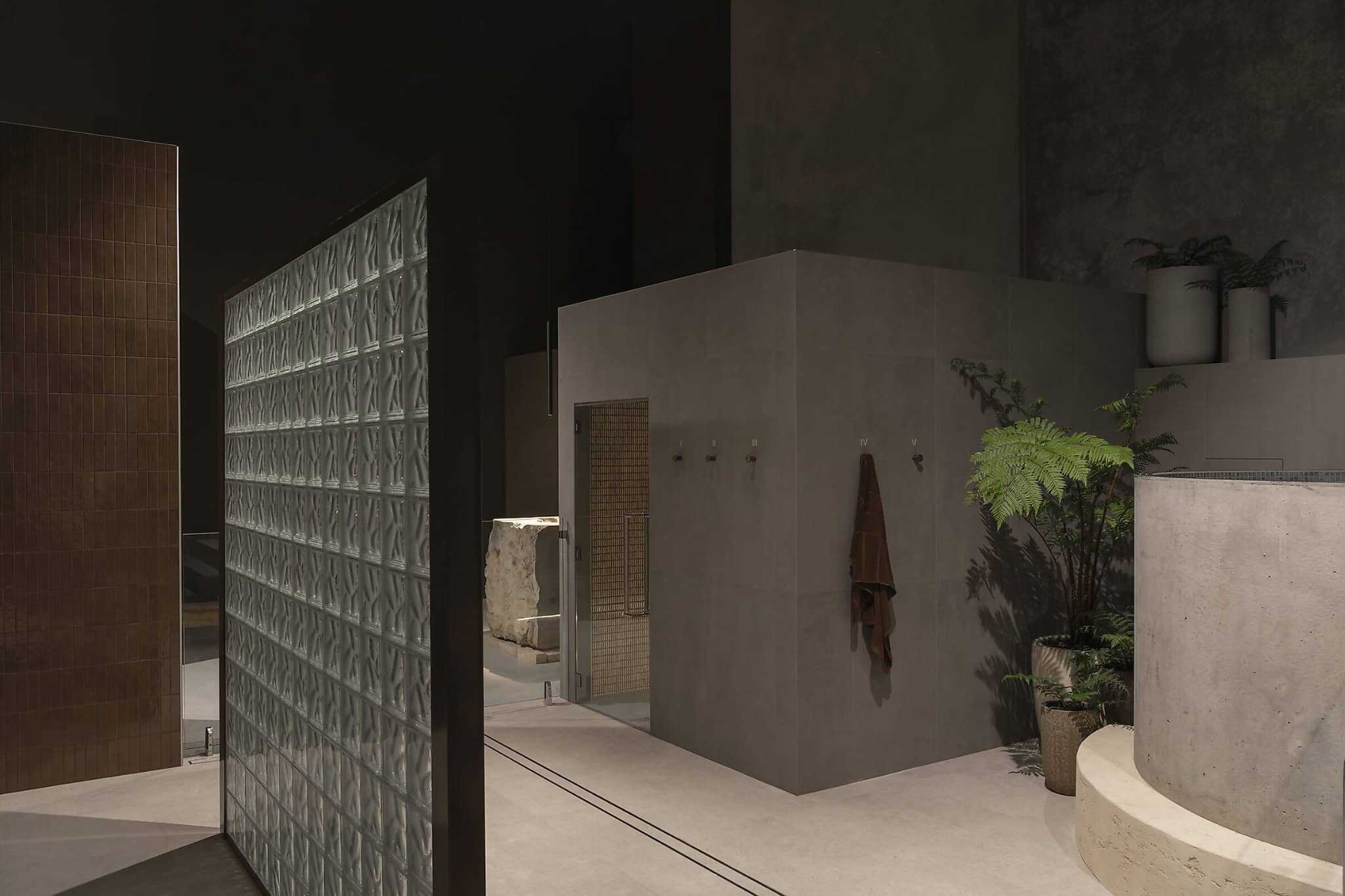 Modern minimalist bathroom interior with concrete walls and green potted plants, showcasing contemporary architecture and interior design elements.