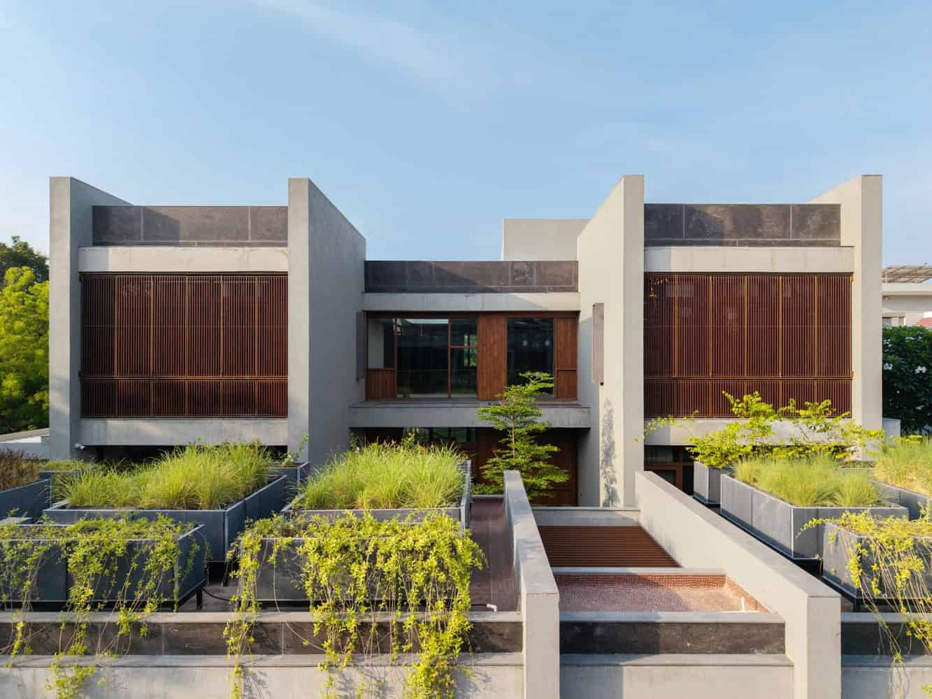 Contemporary modern house with minimalist architecture, wooden accent walls, and lush green rooftop gardens. Sleek design blending natural elements with modern building materials.