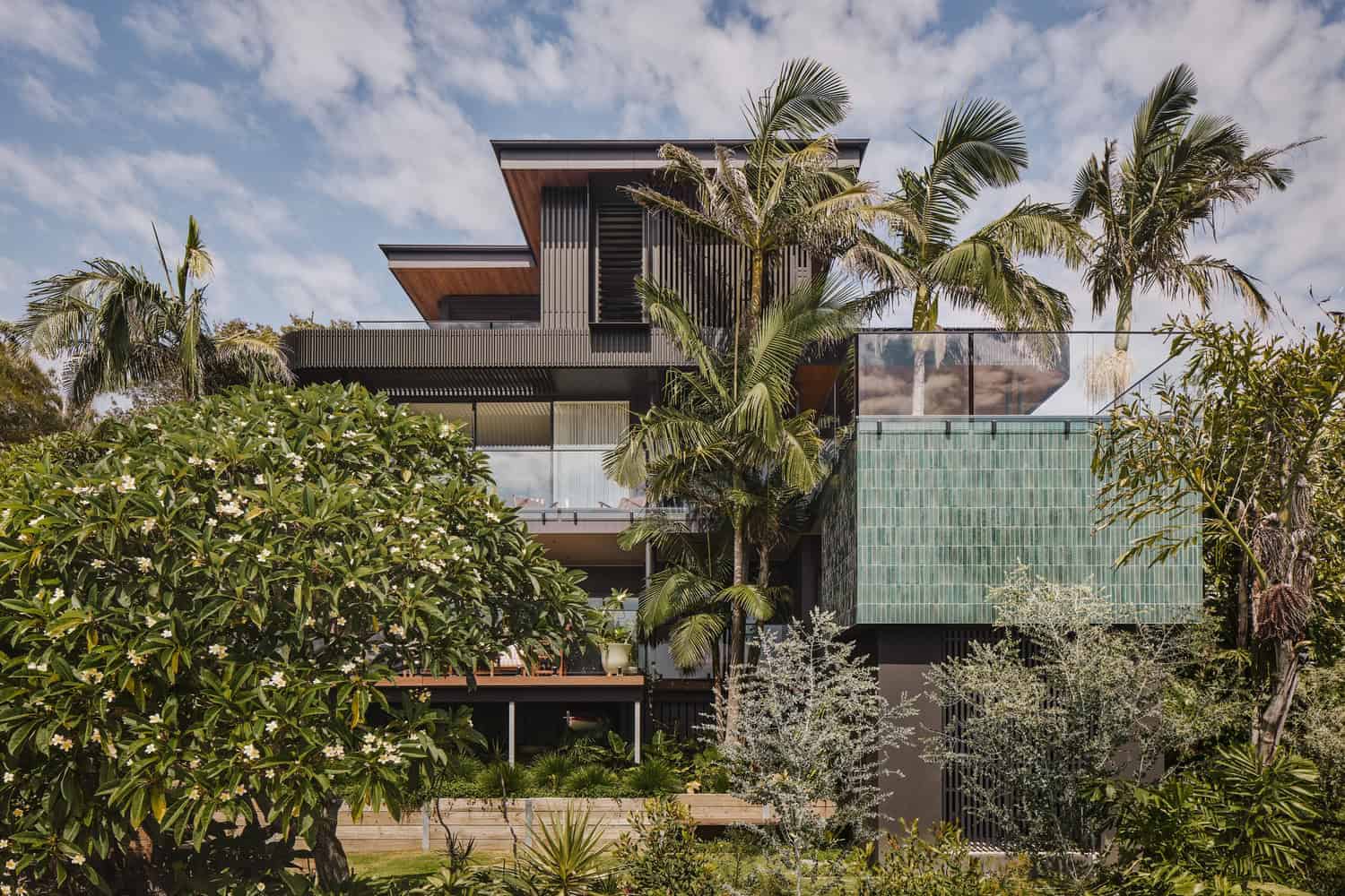 Contemporary modern house with lush tropical landscape, palm trees, sleek design, and eco-friendly architecture.