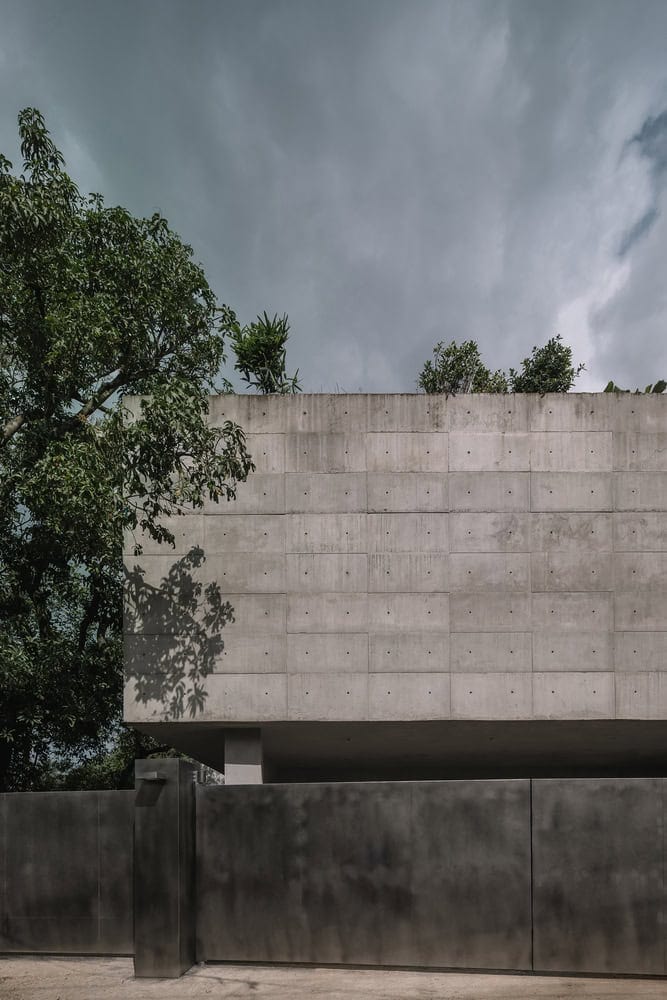 Minimalist concrete modern house with clean lines and natural greenery, showcasing contemporary architecture design and urban residential aesthetics.