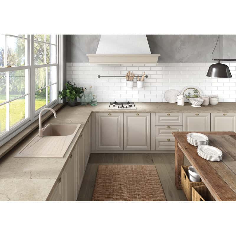 Cucina moderna con arredi beige e tavolo di legno.