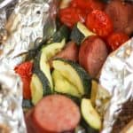 Turkey Sausage and Veggies foil packets with turkey kielbasa sausage zucchini and cherry tomatoes in foil on the grill