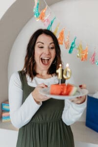 steph wagner blowing out 10 candles on watermelon slice for bariatric food coach birthday and sale