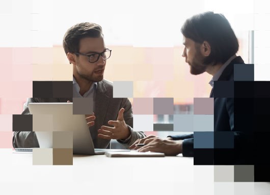 Two professionals discussing HR/ER strategies at a desk with a laptop, representing Case IQ's purpose-built HR case management system.