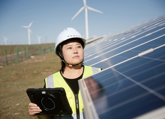 stock image woman in hard hat standing by solar panels