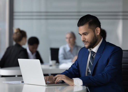 stock photo man in suit at laptop computer desk