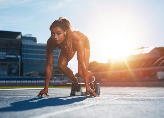 stock image female track athlete in starting line pose