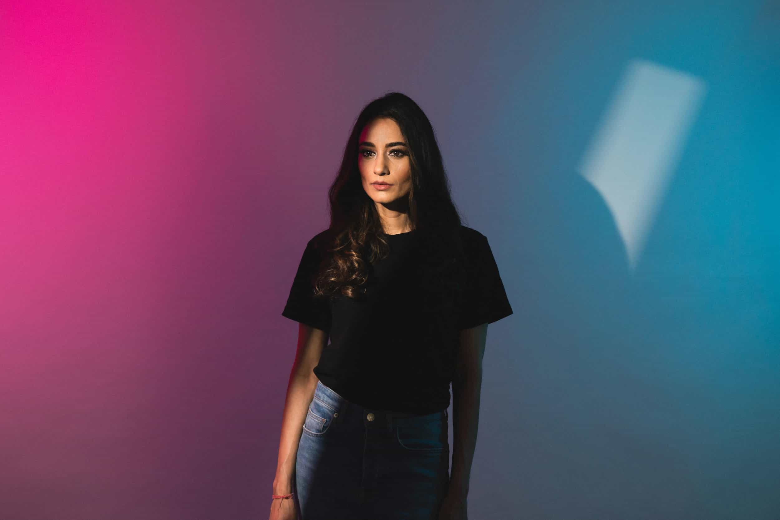 studio-portrait-of-young-female-with-magenta-and-aqua-backdrop
