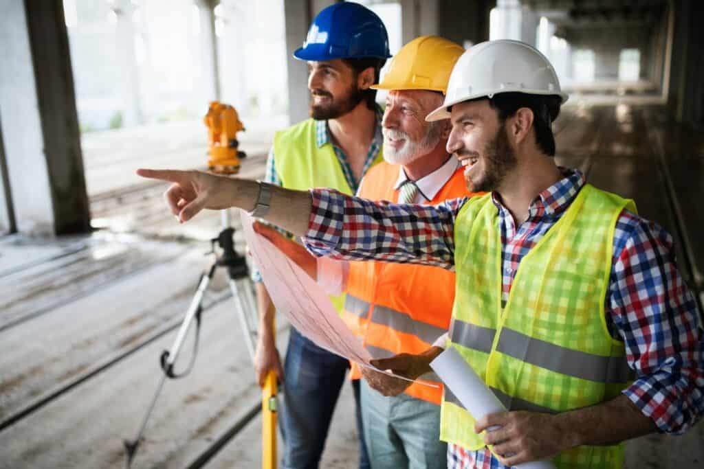 construction engineer with foreman worker checking construction site e1600416419290