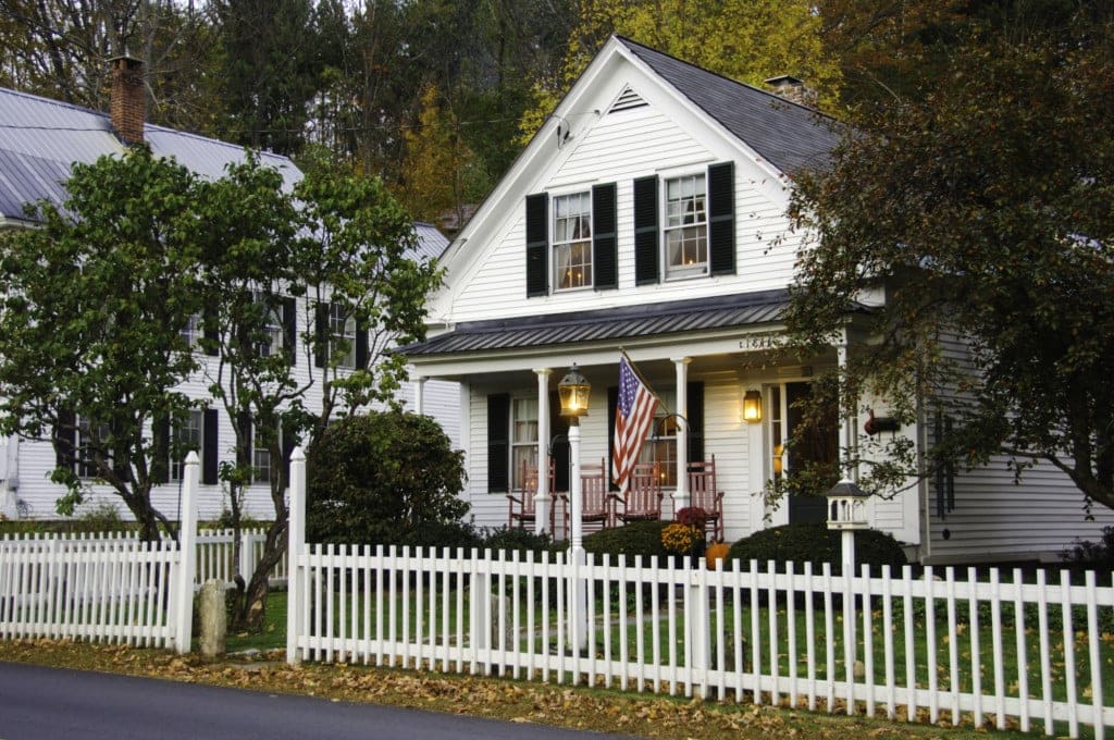 White clapboard house with a white picket fence