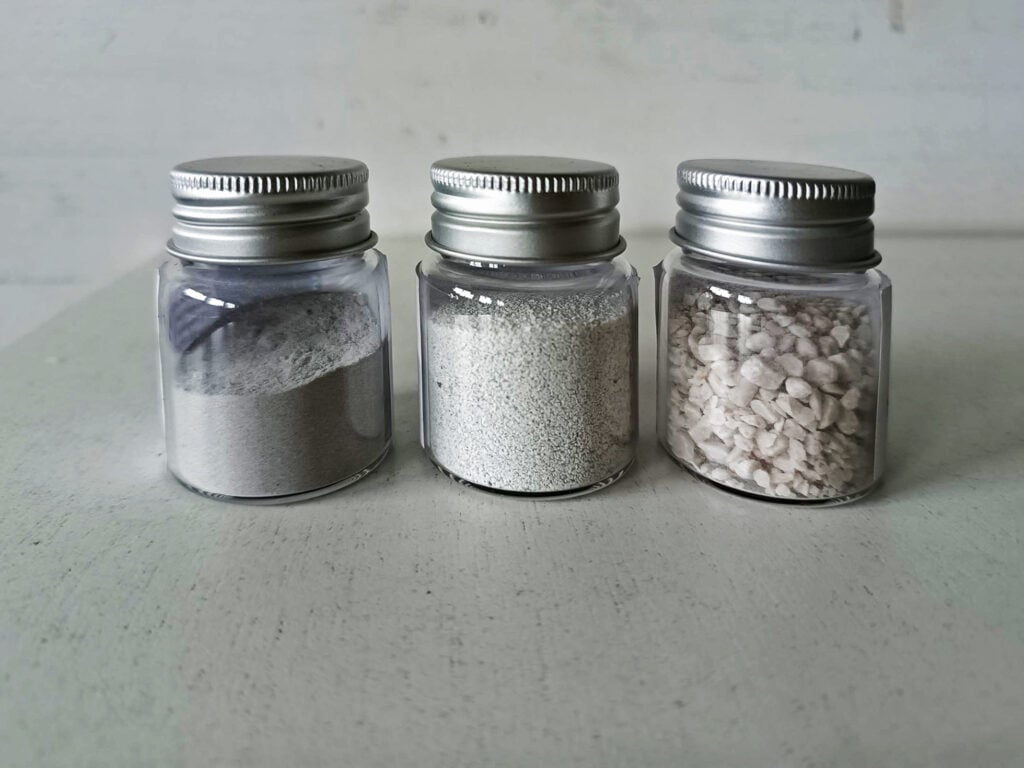 Three jars of different mineral samples.