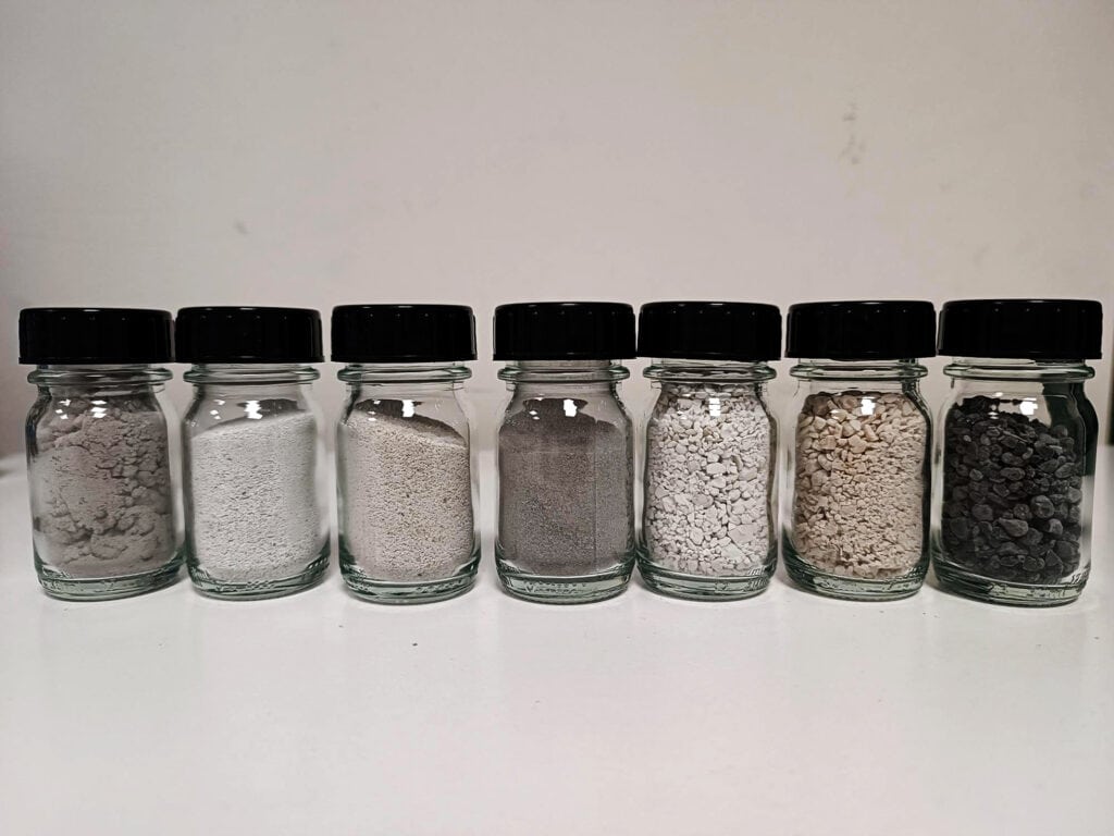 Seven jars with various types of soil