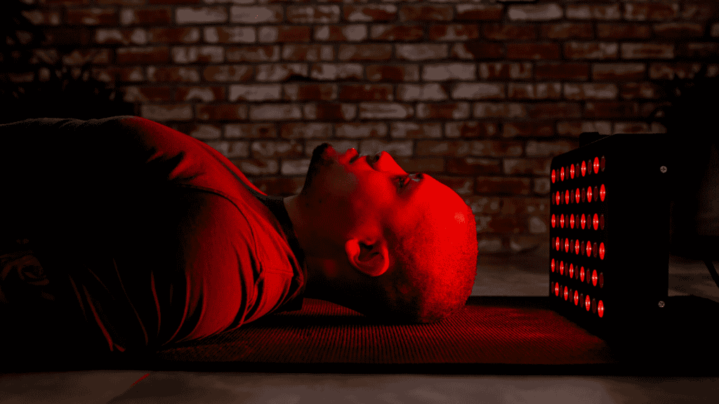 Man laying down in front of a MitoMOD red light therapy panel