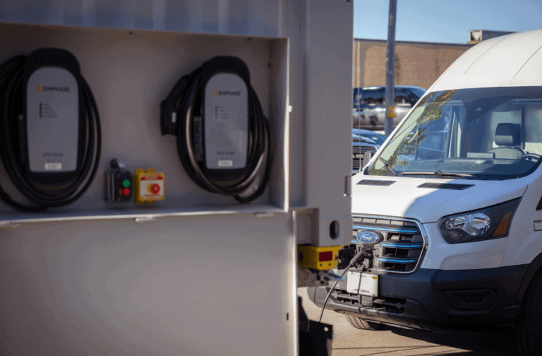 Electric vehicle charging station in front of a white Ford van, promoting clean energy transportation solutions.