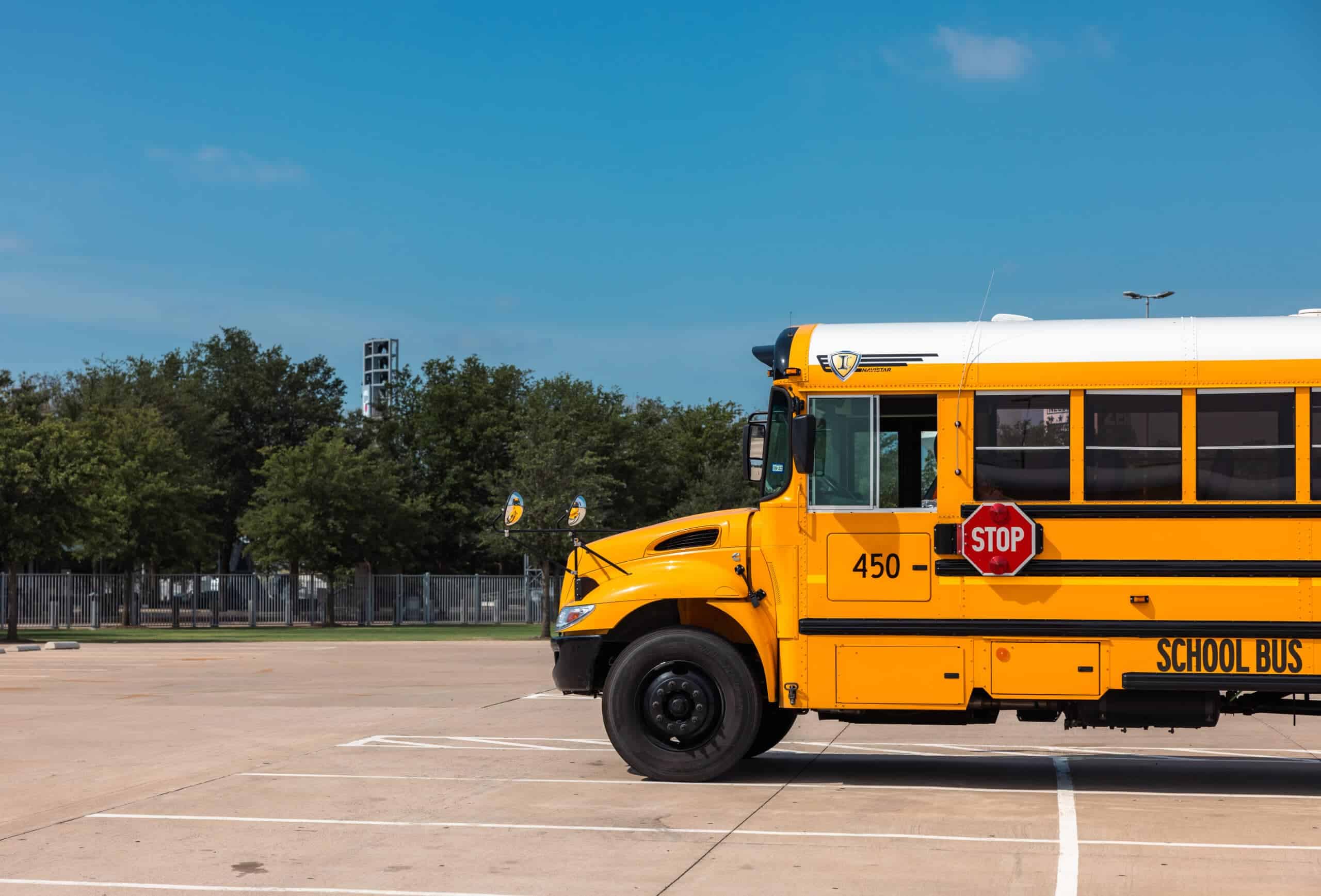 School bus at a parking lot with trees and blue sky in the background, focusing on U.S. energy transportation.