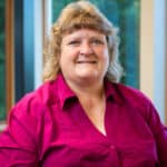 Energy industry professional smiling in office with natural light and window view.