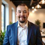 Professional man in business suit smiling in modern office, representing U.S. energy industry leadership and innovation.