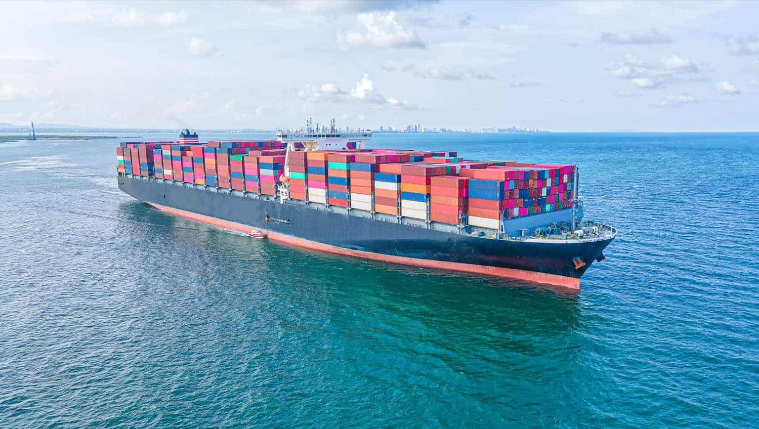 Barge on water with multiple shipping containers