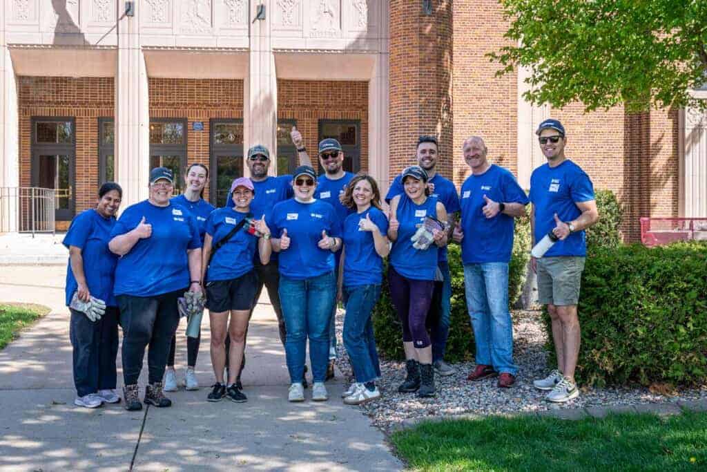 U.S. Energy community cleanup team in blue shirts outdoors.