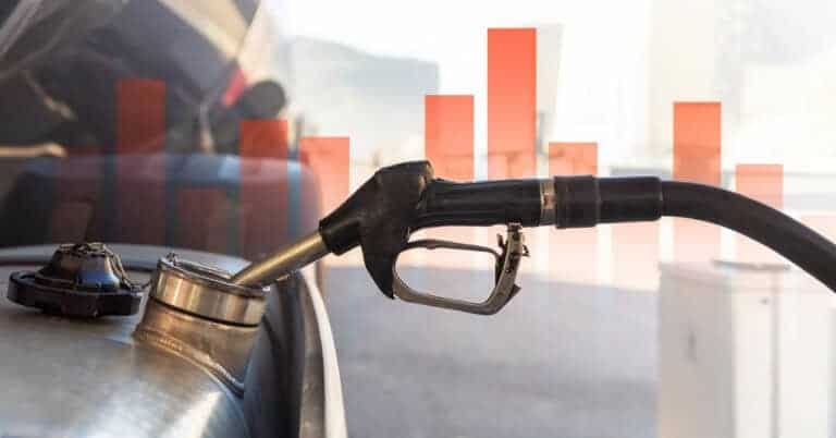 Fuel pump nozzle with finance bar chart in background.