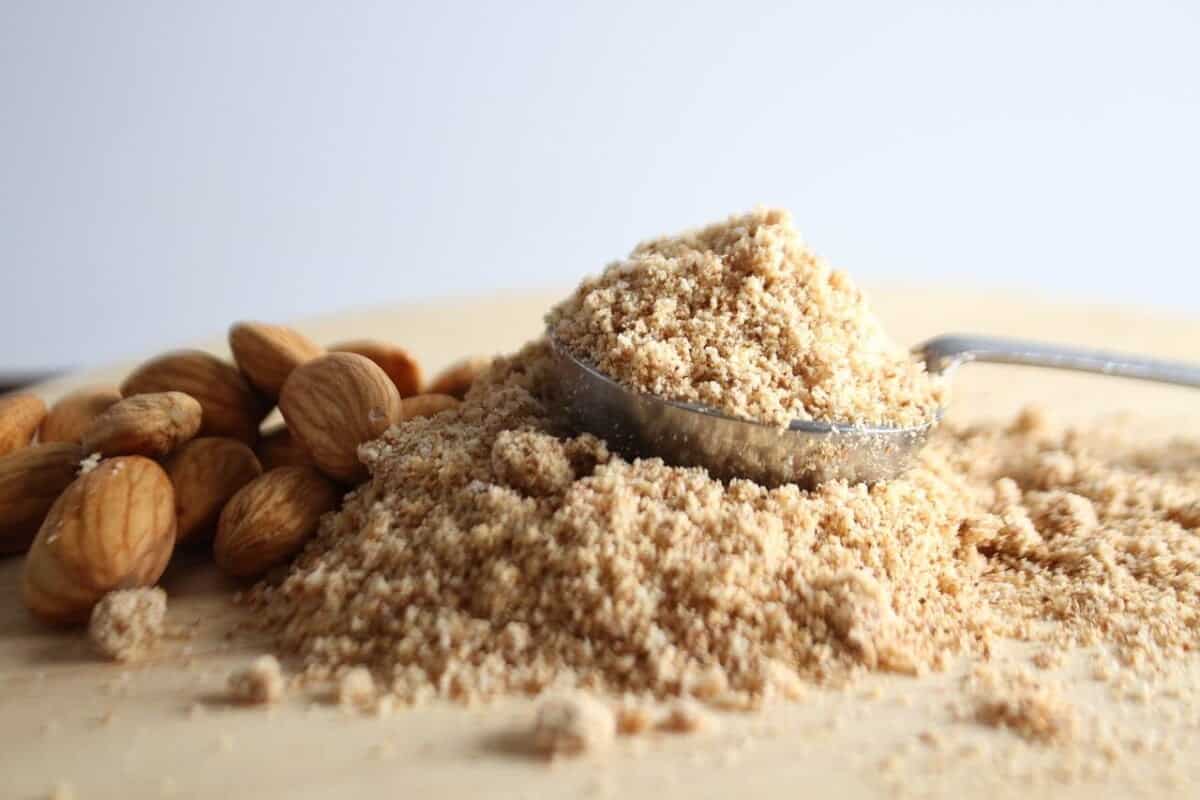 whole almonds and ground almonds on a board