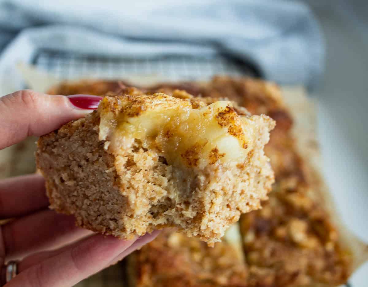 hand holding square of ginger apple cake