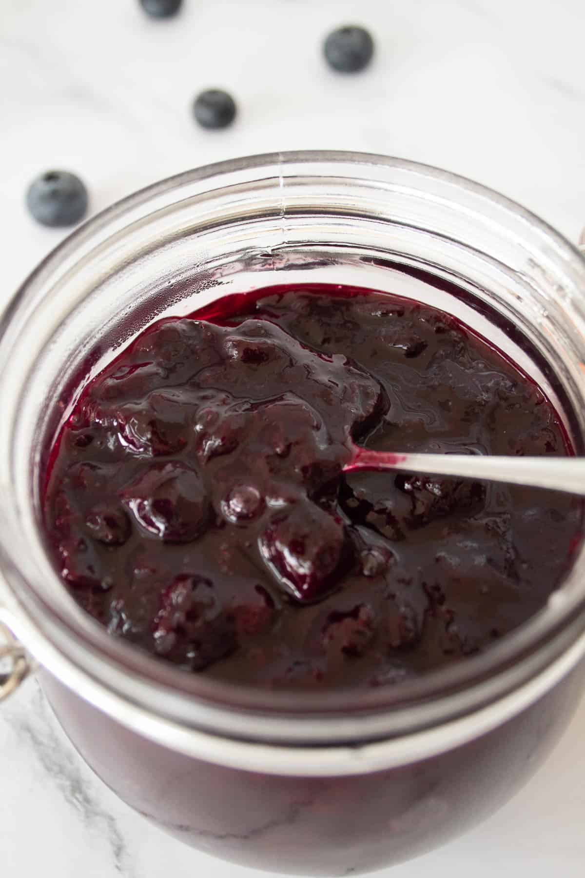 Easy sugar free jam for diabetics in a jar with blueberries in the background